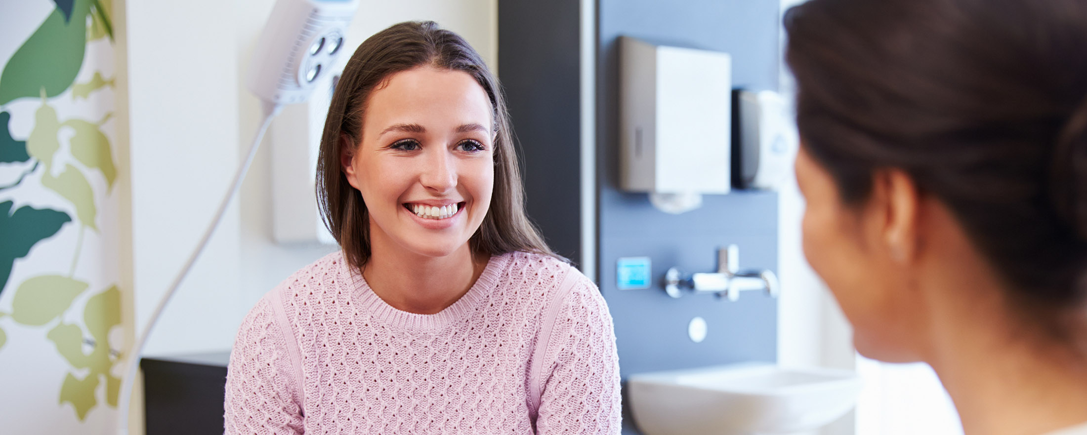 Female Patient And Doctor Have Consultation In Hospital Room